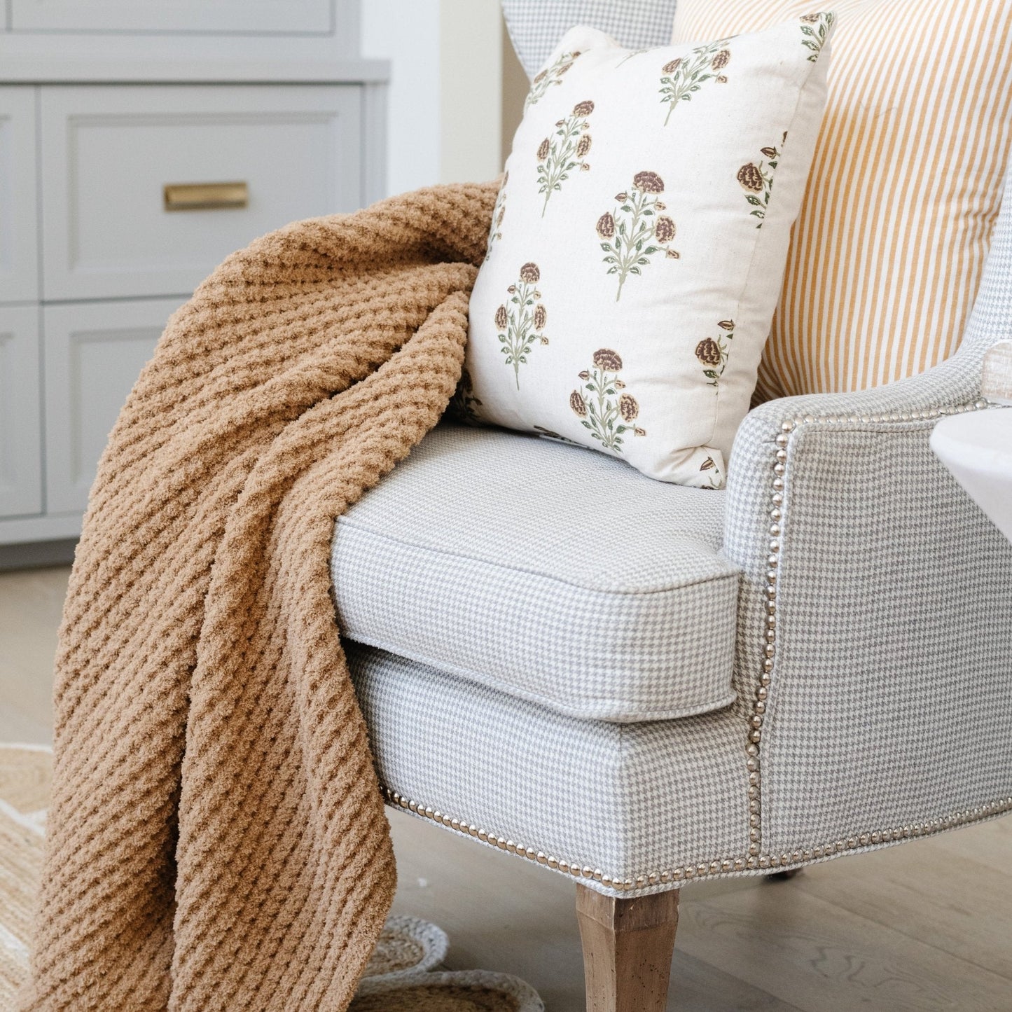 Tan waffle knit blanket draped over living room chair.