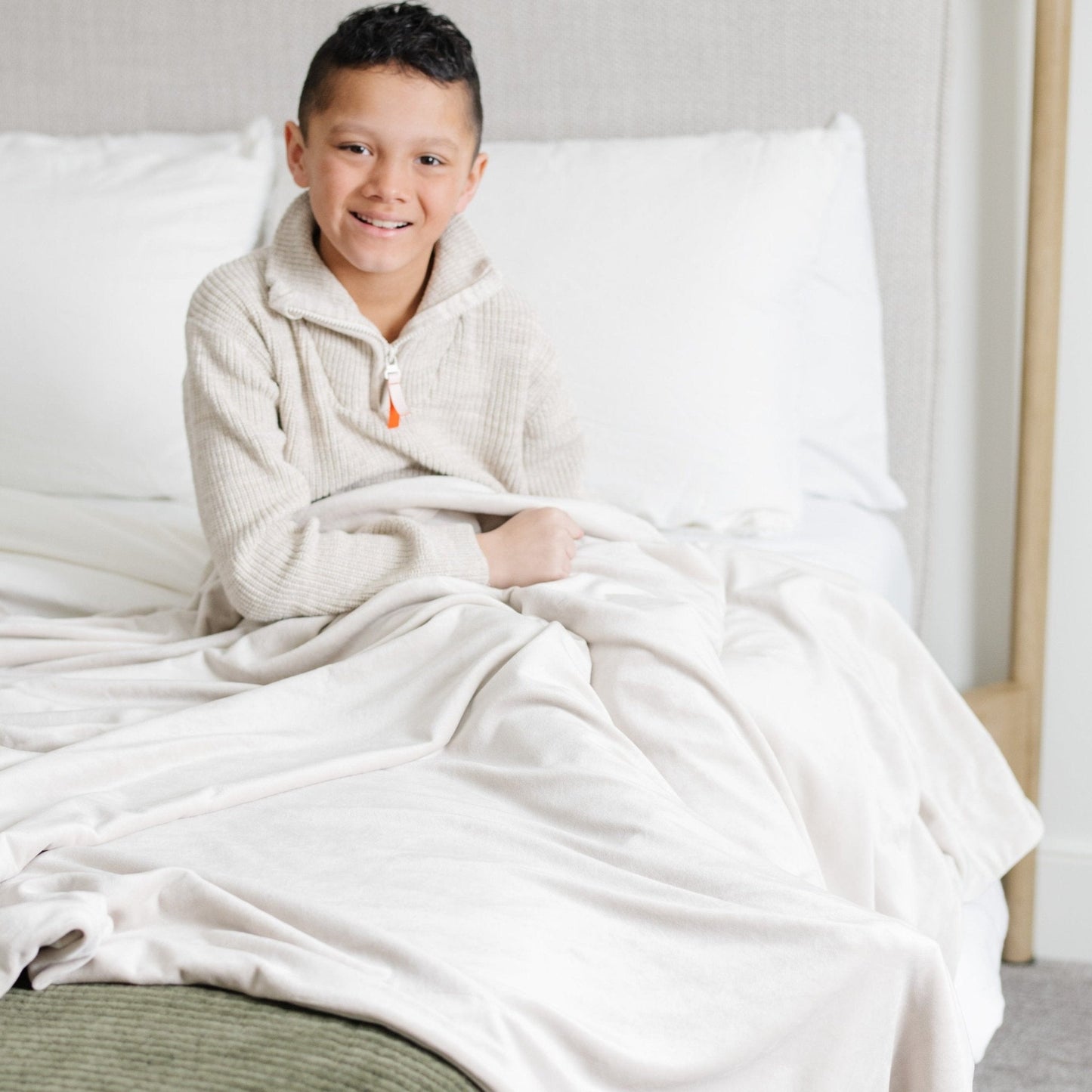 Boy sitting on bed with MINKY STRETCH THROW BLANKETS - Saranoni