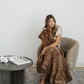 Woman sitting in a chair holding a brown faux fur soft cozy blanket. 