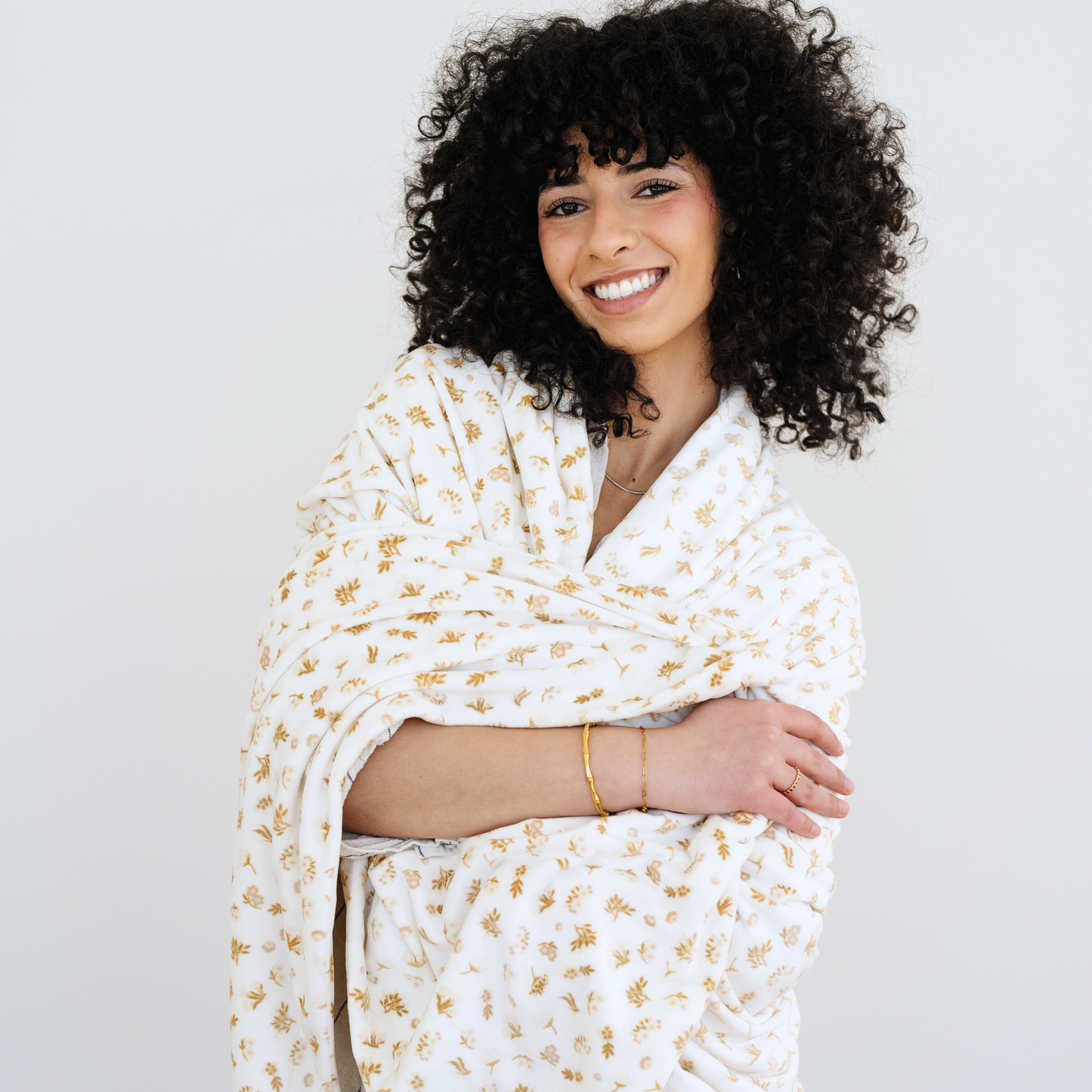 Woman wrapped in a neutral floral printed minky stretch XL blanket. 