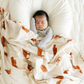 Baby boy snuggled with Highland Cow Bamboo Rayon Muslin Swaddle.