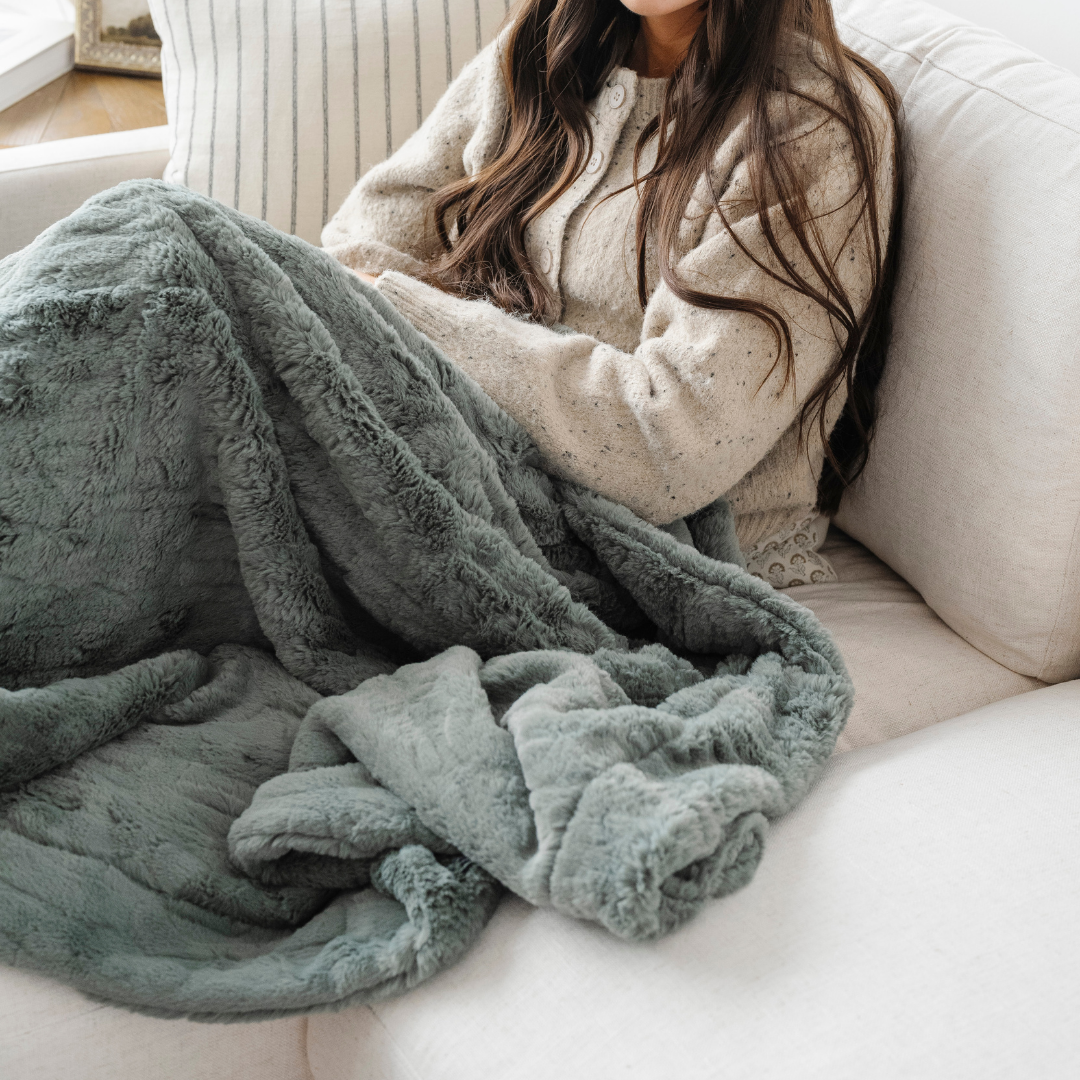 A close shot of a luxurious green patterned faux fur blanket. This Saranoni blanket has a very soft texture and is perfect for luxury living or a bedroom refresh. Enjoy this cozy blanket for years to come!