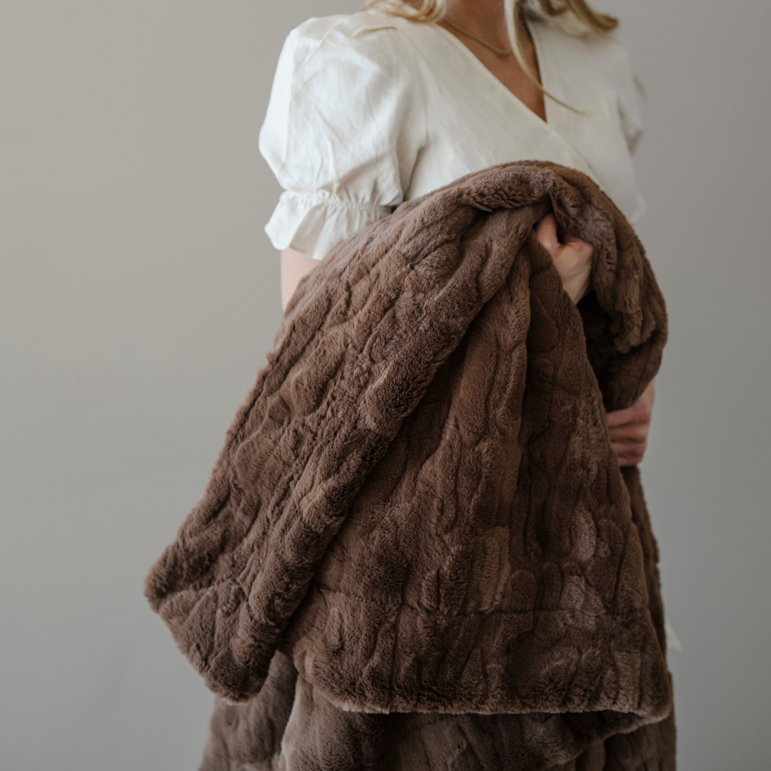 A brown patterned faux fur blanket that is a throw blanket. This Saranoni blanket is luxuriously soft and can be used as home decor, for gifting, or for relaxing. Enjoy this luxury blanket for years to come!
