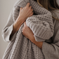 A light tan blanket that is a waffle knit blanket. This luxury blanket is a Saranoni blanket and is super cozy. It can be used for home decor, relaxing, gifting. 