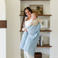 Mom swinging baby wrapped in light blue BAMBONI® RECEIVING BLANKETS - Saranoni