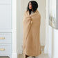 Woman wrapped up in a cozy, tan XL waffle knit blanket. 