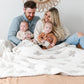 Beautiful family snuggled together in Swiss Cross DOUBLE-LAYER BAMBONI THROW BLANKETS - Saranoni
