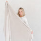 Woman holding out neutral color MINKY STRETCH THROW BLANKETS - Saranoni