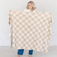 Woman holding out beautiful large checkered MINKY STRETCH XL THROW BLANKETS - Saranoni