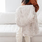 PATTERNED FAUX FUR XL THROW BLANKETS - Comfy Saranoni blanket on a bed, perfect for snuggling up.
