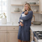 Mother holding baby at home while wearing blue waffle knit robe.